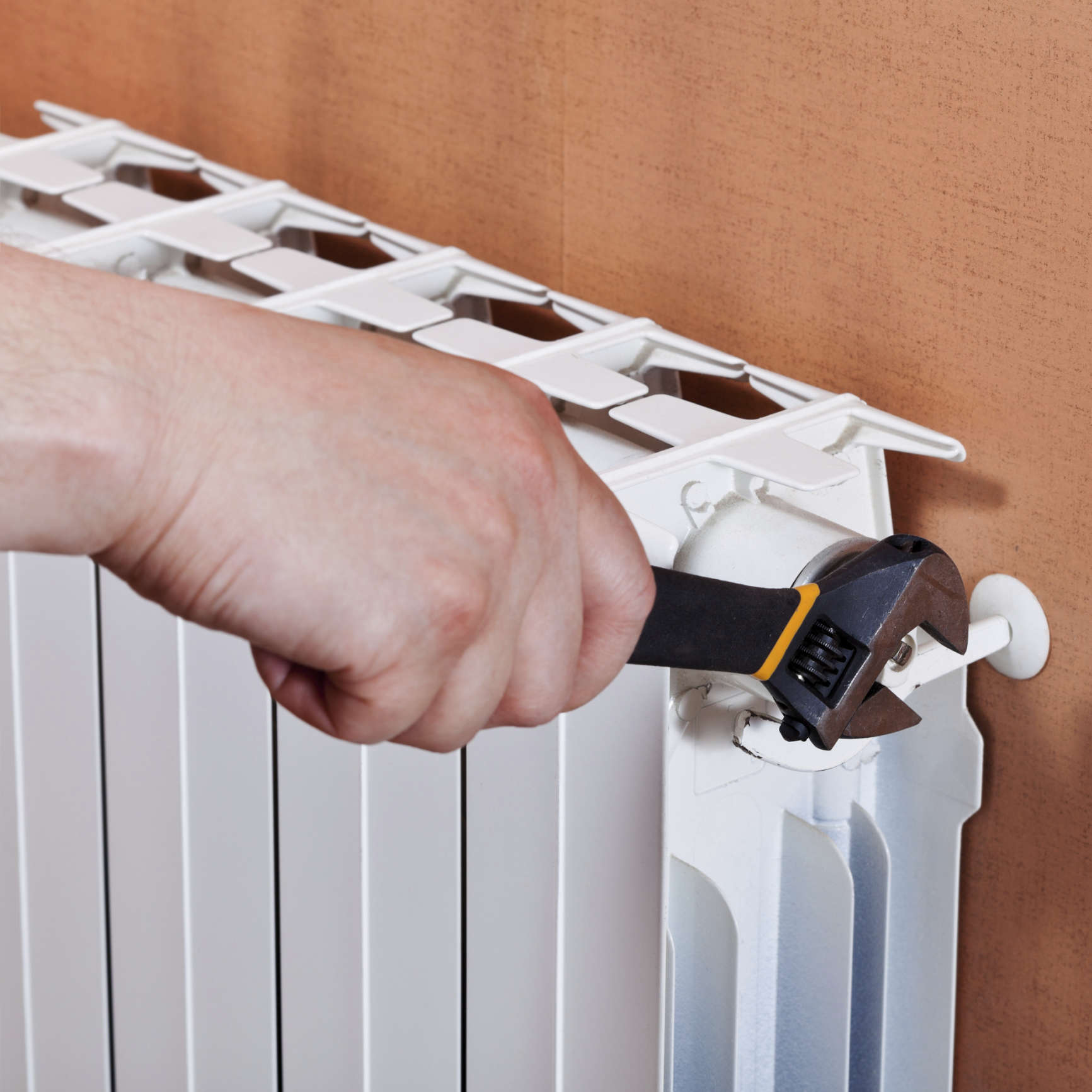 A man adjusting heating radiator