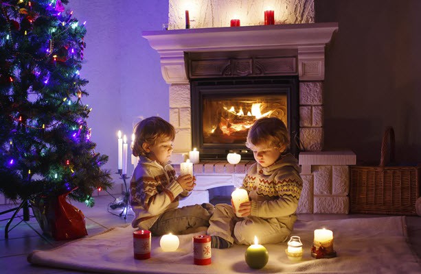 Kids celebrating Christmas next to a warm fireplace