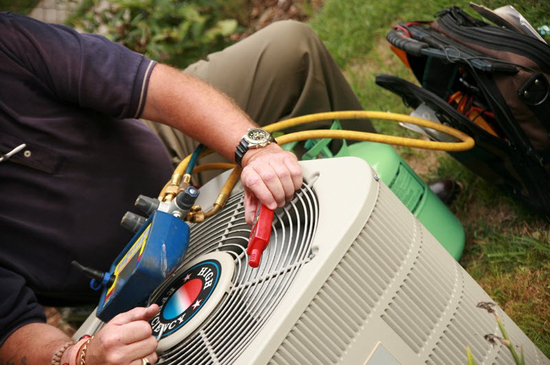 An HVAC contractor performing preventative AC maintenance
