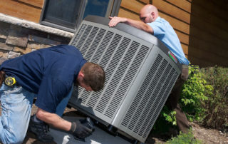 Two HVAC contractors installing an AC unit