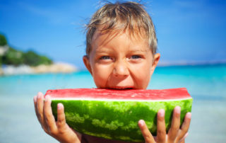 Little boy on Miami Beach eating a slice of watermelon.