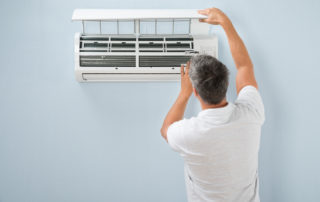 Rear View Of A Man Cleaning Air Conditioning System