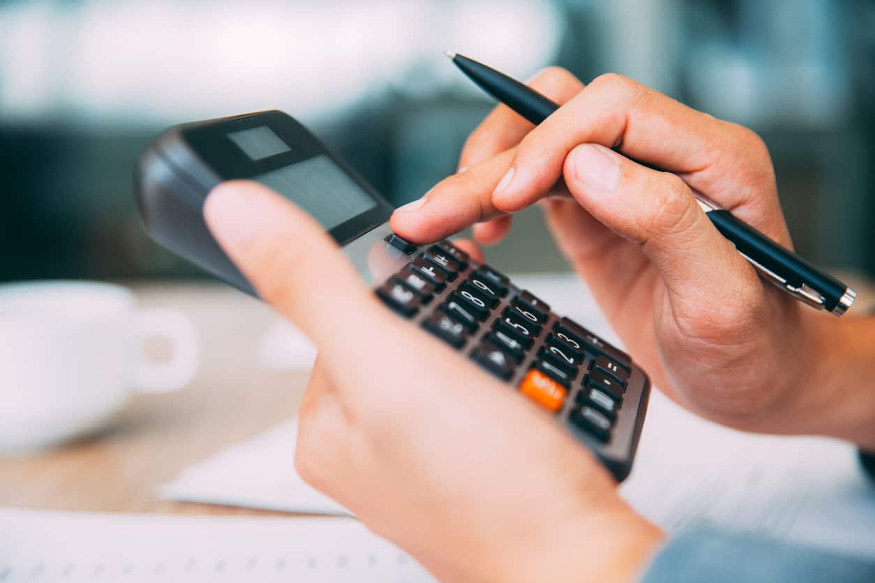 Close-up of male hands using calculator. Unrecognizable accountant holding pen when pushing button on calculator. Finance concept