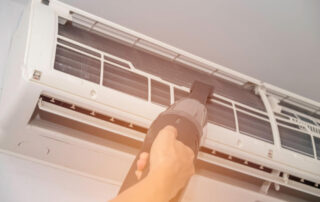 Cleaning an air conditioning unit using a small vacuum cleaner