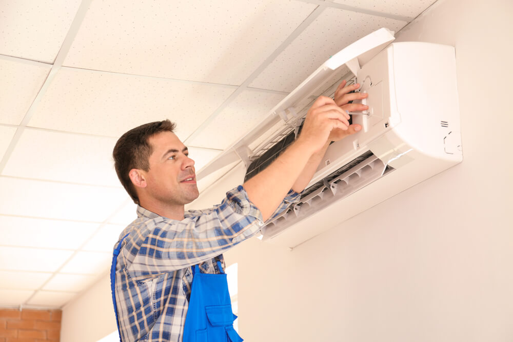 Electrician Repairing Air Conditioner Indoors