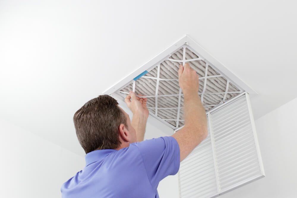 Person Removing Ceiling Air Filter.
