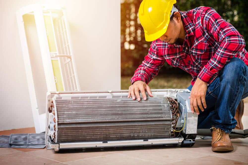 Air Conditioning Service, Repair & Maintenance Concept. The Technician Repairing the Air Conditioner