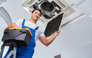 Worker Repairing Ceiling Air Conditioning Unit