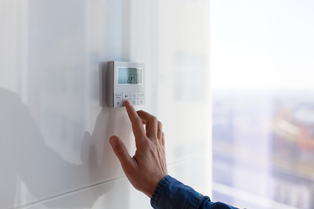 Man Fixing Air Conditioning and Heating Control Panel