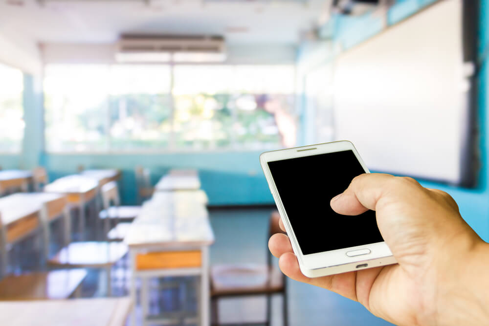 Man Use Mobile Phone Blur Image of the Classroom Is Empty as Background
