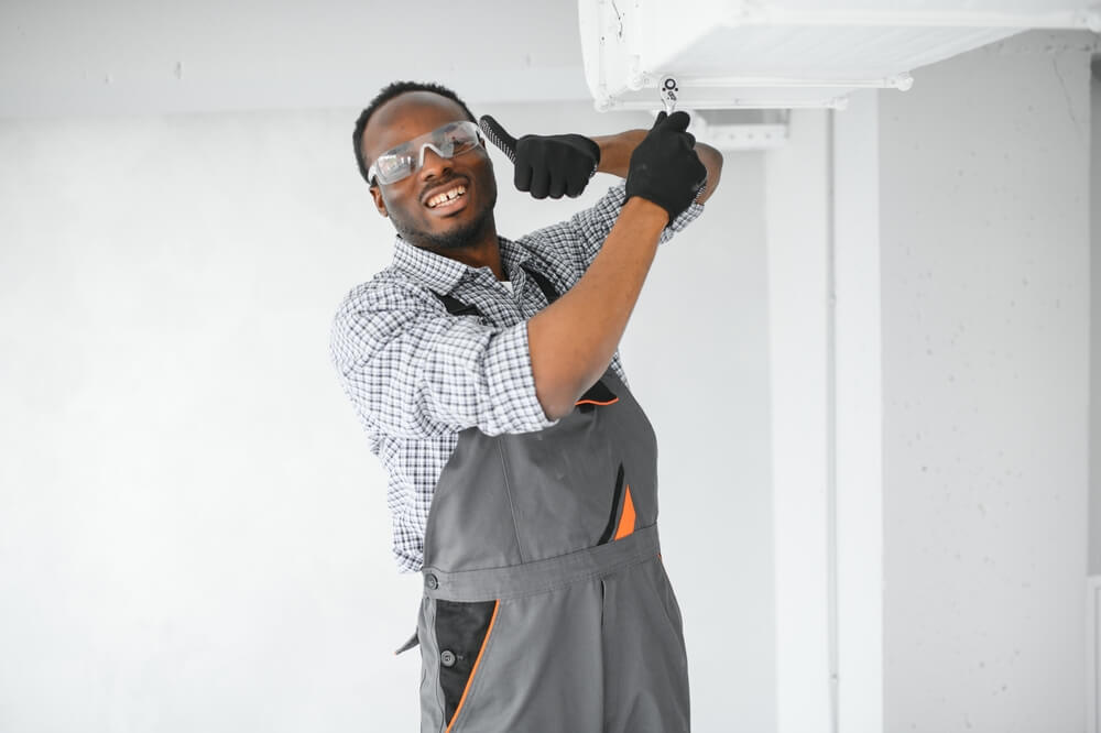 HVAC technician worker testing newly installed ventilation system.